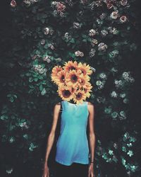 Rear view of woman standing against plants