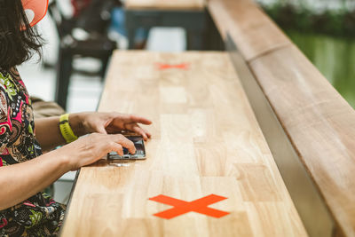 Midsection of woman holding wooden table