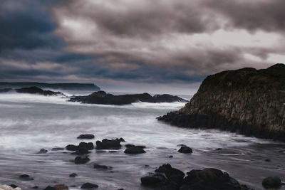 Scenic view of rocks on sea against sky