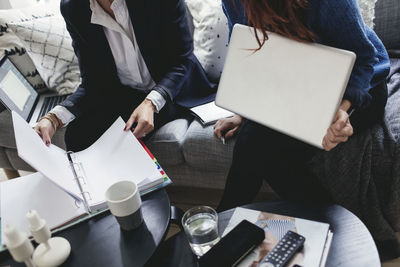 Midsection of female colleagues working in home office