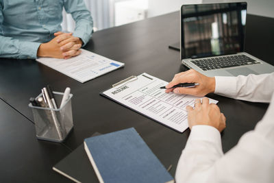 Midsection of business colleagues working on table