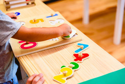 Midsection of baby girl playing with toys on table