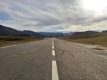 Empty road by mountain against sky