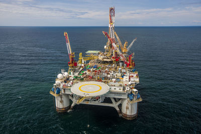 High angle view of cranes on oil exploration platform amidst sea