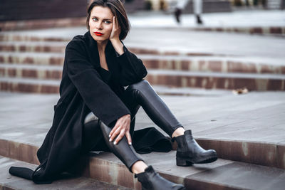 Portrait of a young woman sitting outdoors