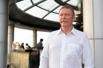 Portrait of man standing against wall