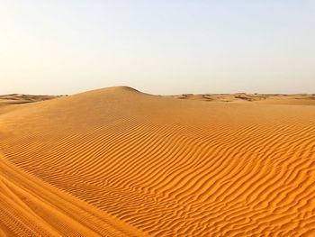 Sand dunes in desert against clear sky