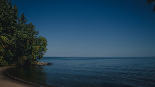 Scenic view of sea against clear blue sky