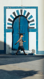 Full length of woman standing against wall