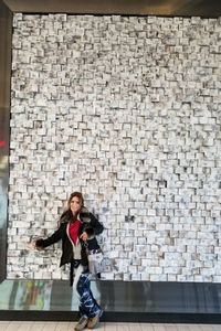 Portrait of a woman standing against brick wall