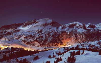 Scenic view of snowcapped mountain against sky at night 