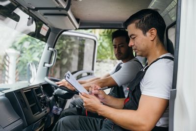 Young man using mobile phone while sitting in car