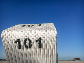 Low angle view of text on building against clear blue sky