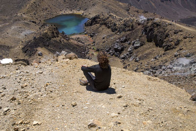 High angle view of man sitting on rock