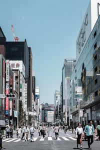 Group of people on city street against buildings