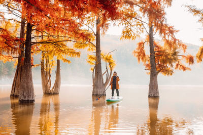 Rear view of woman standing in lake