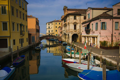 Colorful houses and boats along canal vena in the romantic center of chioggia, veneto, italy