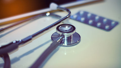 High angle view of stethoscope with blister pack on table