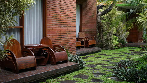 Empty chairs in yard against building