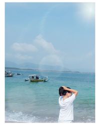 Woman standing by sea against sky