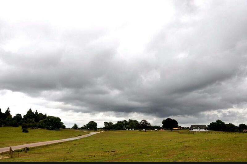 sky, grass, cloud - sky, cloudy, field, landscape, grassy, tree, green color, cloud, overcast, tranquil scene, nature, tranquility, weather, beauty in nature, scenics, building exterior, built structure, rural scene