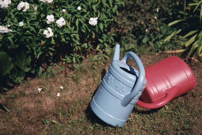 High angle view of two water cans on grass in the garden