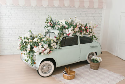 Vintage mint car decorated with flowers in the photo zone in a romantic style for spring day