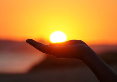 Cropped image of hand holding sun