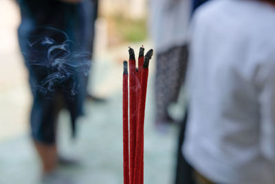 Close-up of red candles on wood against temple