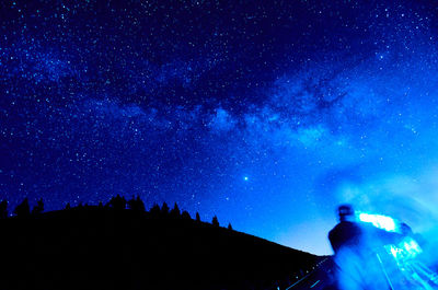 Low angle view of silhouette man standing against sky at night