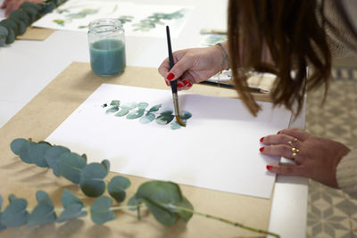 Midsection of woman painting on table