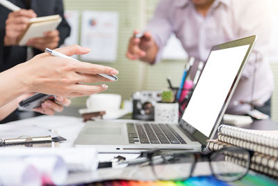 Midsection of business people working on table