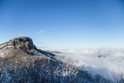 Scenic view of snow covered mountains against blue sky