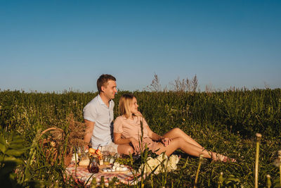 Young couple on land against clear sky