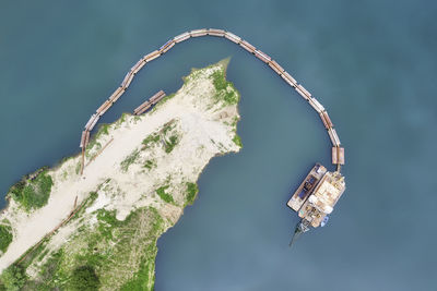 Close-up of water wheel on rock against sky