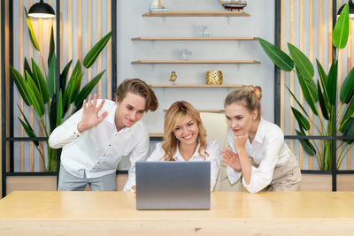 Portrait of smiling woman using laptop at table