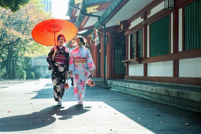 Woman holding umbrella in city