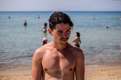 Close-up of shirtless man standing at beach