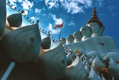 Low angle view of sculptures at temple against sky