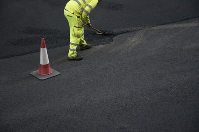 Low section of person with umbrella on road