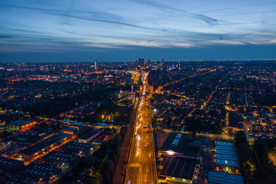 High angle view of illuminated city against sky at dusk