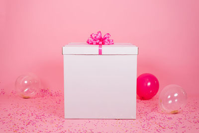 Extremely huge birthday, valentine's day, mom's day present in the room with pink balloons