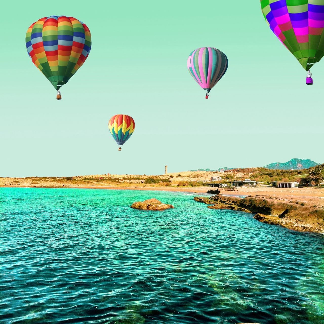 sea, water, parachute, flying, mid-air, multi colored, blue, clear sky, hot air balloon, paragliding, vacations, scenics, tranquility, leisure activity, adventure, tranquil scene, waterfront, beauty in nature, sky, fun