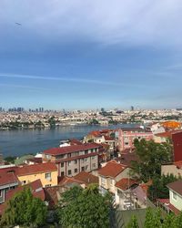 High angle view of townscape by sea against sky