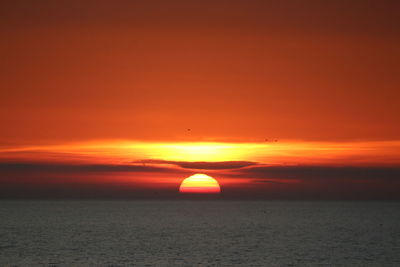 Scenic view of sea against romantic sky at sunset