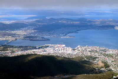 High angle view of town by sea against sky