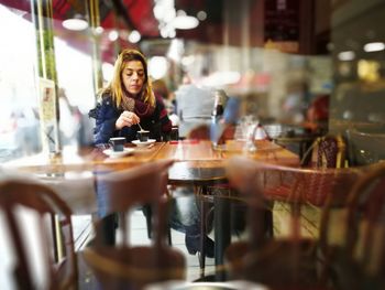 Young woman sitting on table at cafe