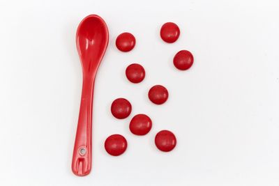 Close-up of red berries over white background