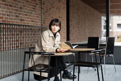 Young woman using laptop while sitting on table