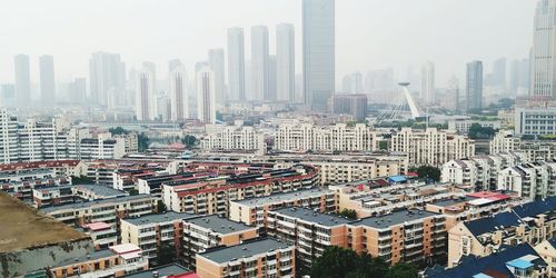 High angle view of modern buildings in city against sky